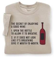 A folded beige shirt with a red bottle and black text

Description automatically generated
