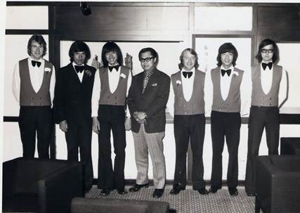 A group of men standing in front of a window

AI-generated content may be incorrect.